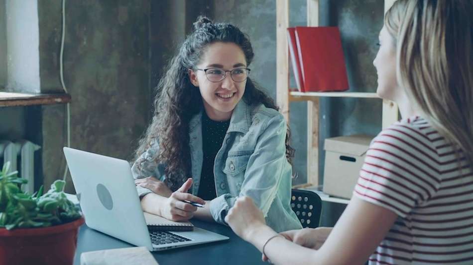 HubSpot CRM für Beratungen: Zwei Frauen unterhalten sich freundlich. 