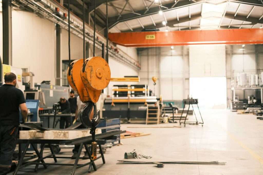 Foto von Cemrecan Yurtman auf Unsplash - Ein Mann bei der Arbeit an einer Maschine in einer Fabrik
      